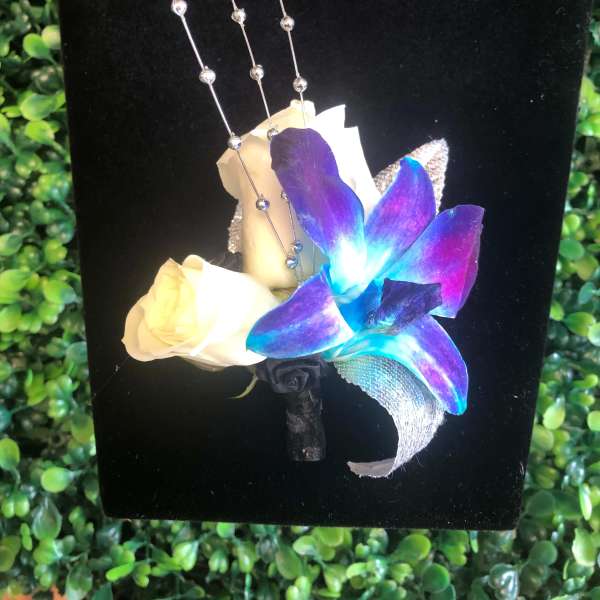Boutonniere with white rose and blue-purple orchid on black backing