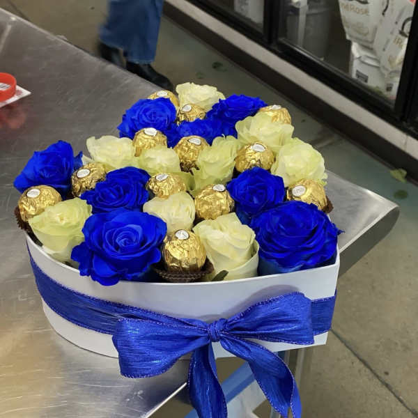 Blue and white roses with gold-wrapped chocolates in a white gift box