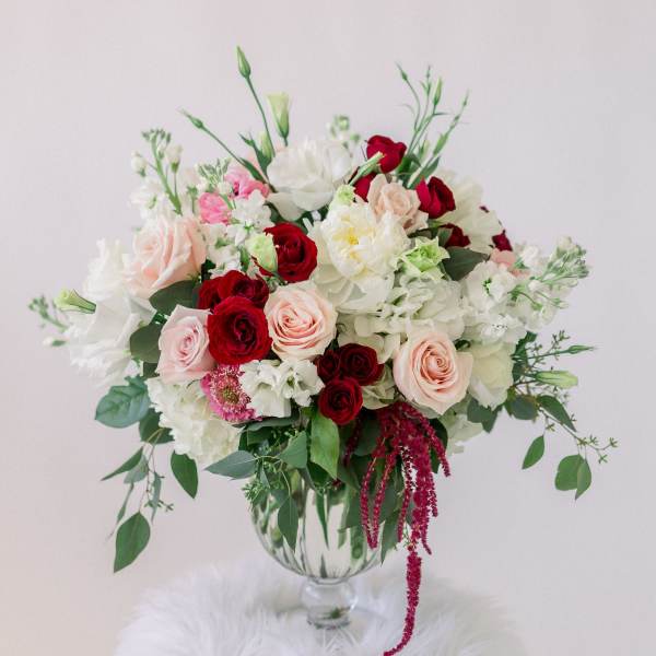 Bouquet of red, blush, and white flowers in a clear glass vase