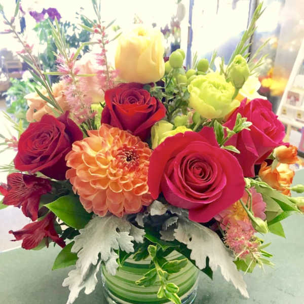 Mixed bouquet of roses and dahlias in a glass vase