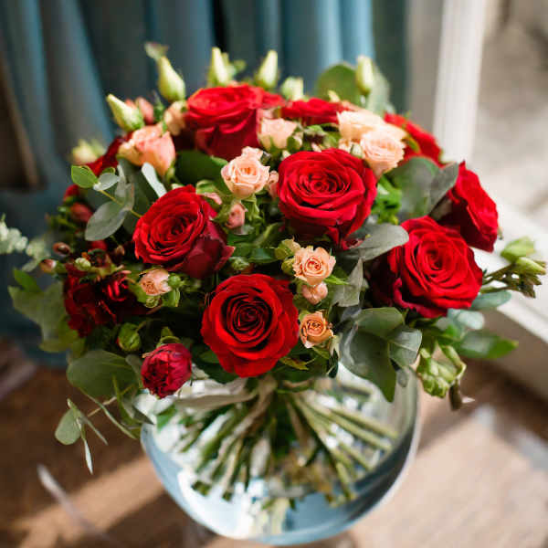 Bouquet of red and peach roses in a glass vase