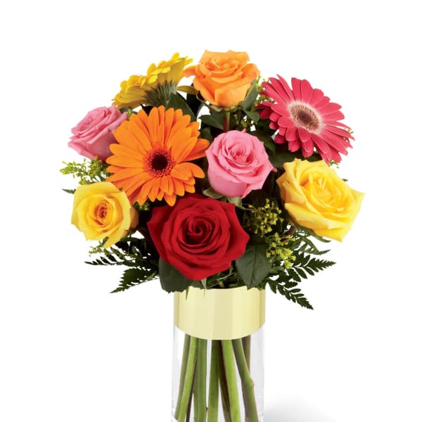 Mixed bouquet of roses and gerbera daisies in a clear glass vase