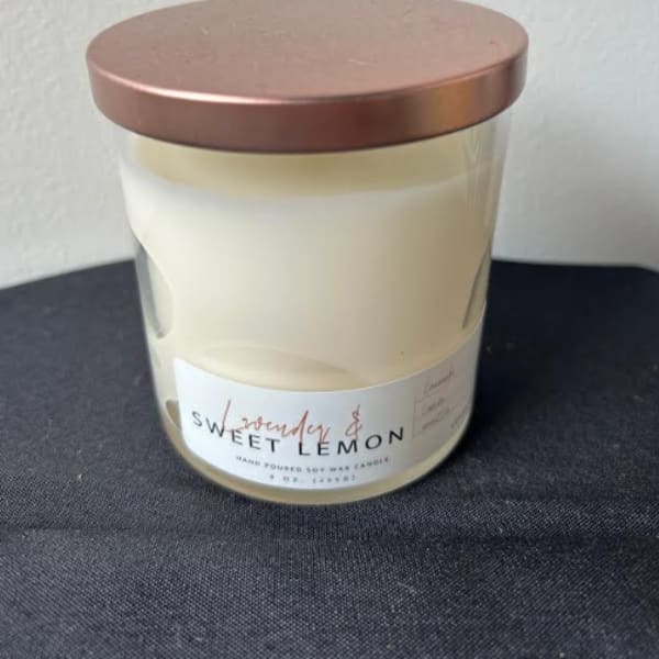 White soy wax candle in a glass jar with a copper lid labeled lavender and sweet lemon