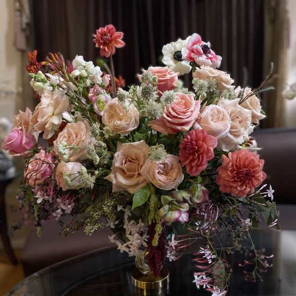 Mixed pink and peach floral arrangement in a gold vase