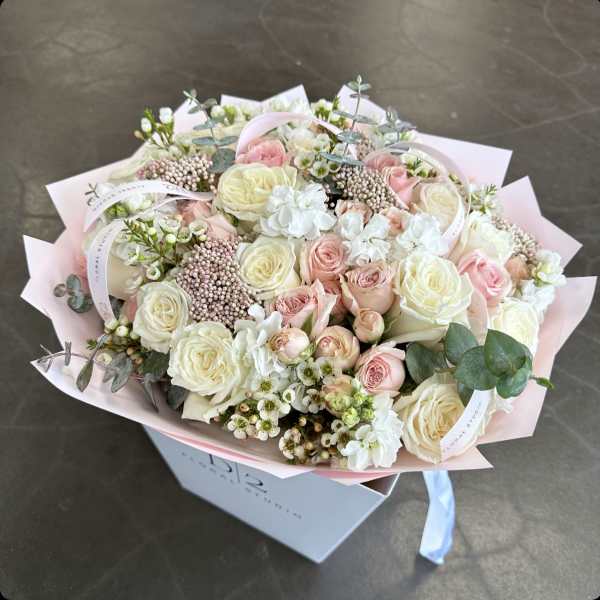 Bouquet of pale pink and white roses with small white blooms