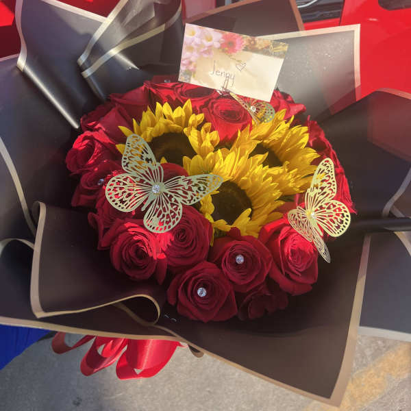 Bouquet of red roses and yellow sunflowers wrapped in black paper