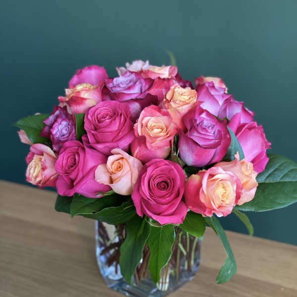 Pink and peach roses arranged in a clear glass vase