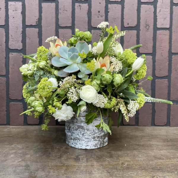 Mixed floral arrangement in a birch-style container with a blue succulent centerpiece