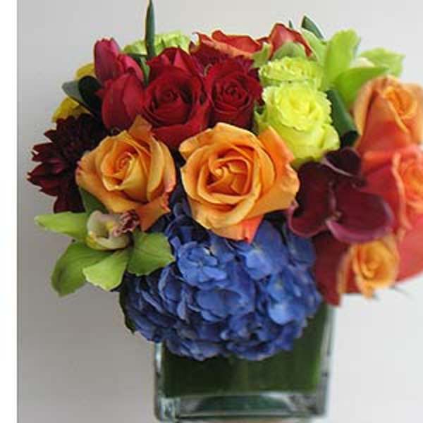 Colorful bouquet of roses and hydrangeas in a clear glass vase