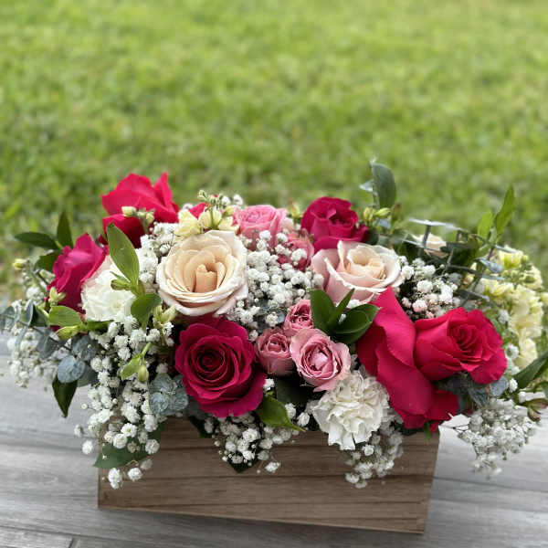 Mixed roses and baby's breath in a wooden box arrangement