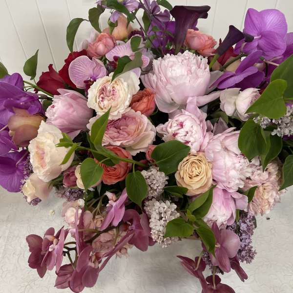 Mixed pink and purple bouquet with roses, orchids, and calla lilies