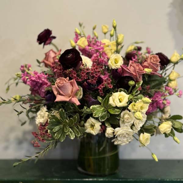 Mixed bouquet of roses and small blooms in a glass vase