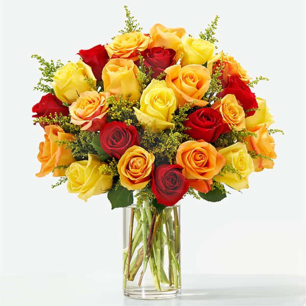 Bouquet of red, yellow, and orange roses in a clear glass vase