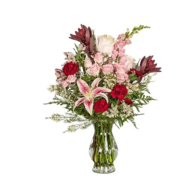 Mixed pink and red bouquet in a clear glass vase
