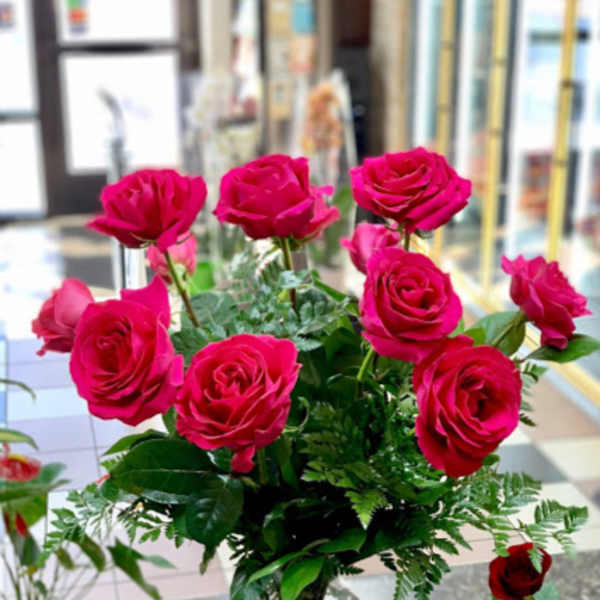 Hot pink roses arranged in a clear glass vase