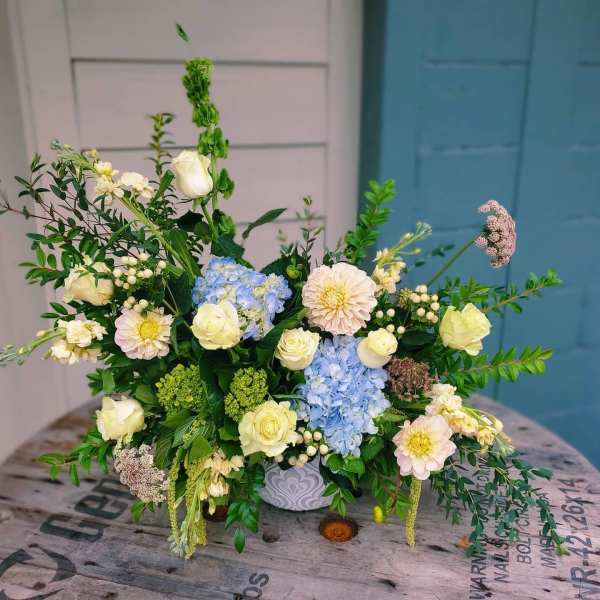 Mixed bouquet with blue hydrangeas, white roses, and pale pink blooms