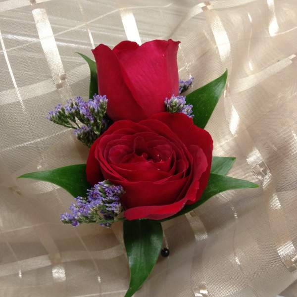 Two red roses with purple filler wrapped in beige mesh
