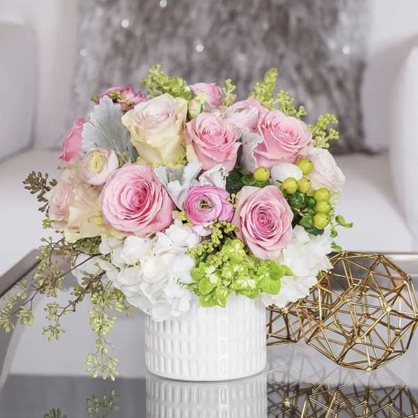 Pink and white rose bouquet in a white vase
