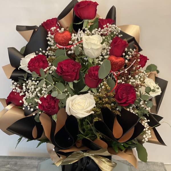 Bouquet of red and white roses with baby’s breath and heart picks