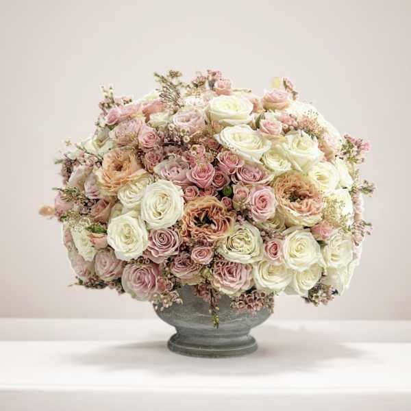 Large bouquet of pink and white roses in a gray vase