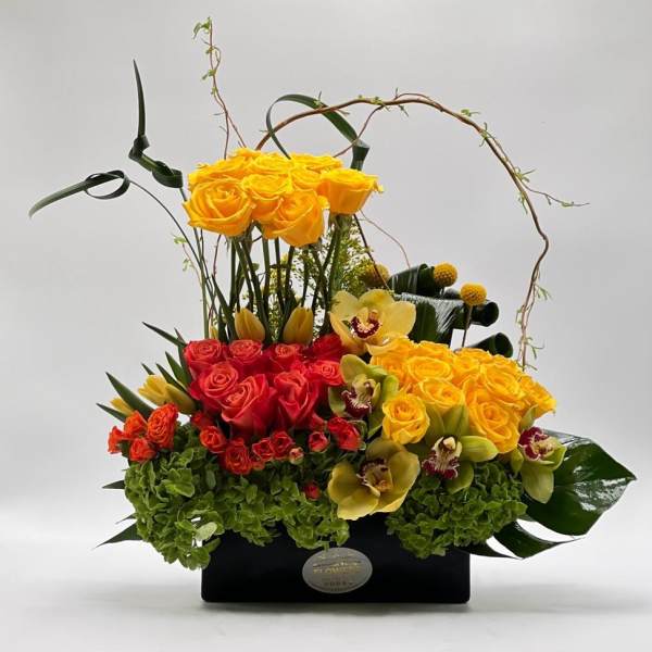 Yellow and red rose arrangement in a black box with orchids