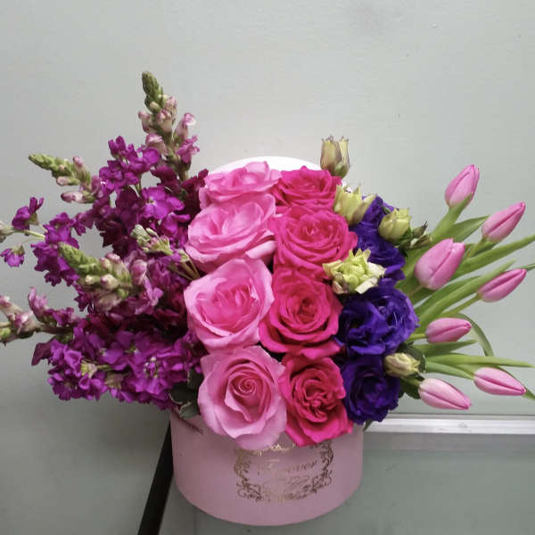 Pink and purple rose bouquet with tulips in a round pink box