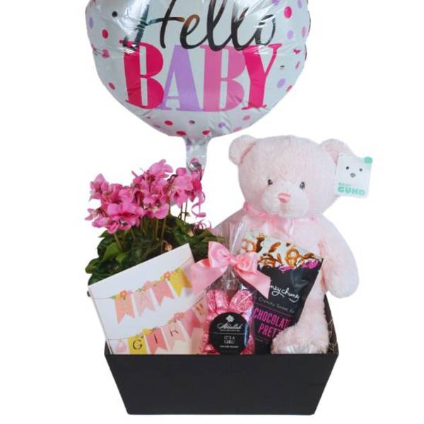 Baby gift basket with a balloon, teddy bear, flowers, and treats
