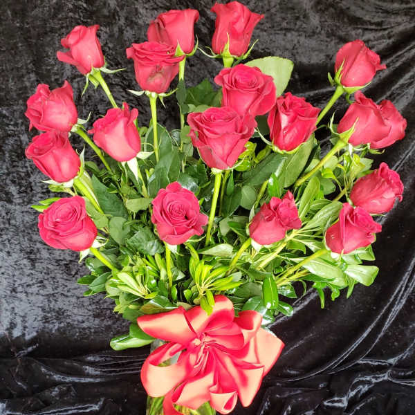 Bouquet of red roses in a glass vase with a red ribbon