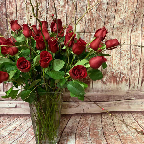 Red roses arranged in a clear glass vase