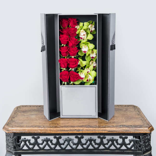Boxed arrangement of red roses and green orchids