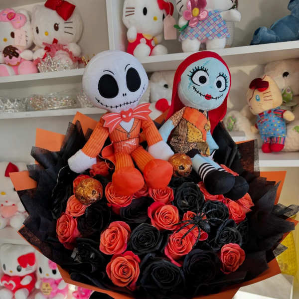 Bouquet of black and orange roses with two plush dolls on top