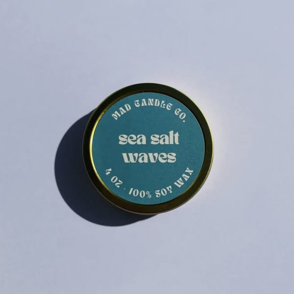 Round candle tin labeled "sea salt waves"