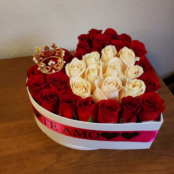 Heart-shaped box of red and cream roses with a small crown topper