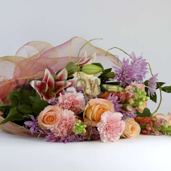 Bouquet of peach and pink flowers wrapped in pink mesh