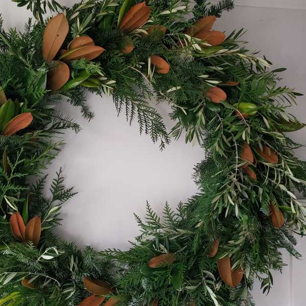 Large green foliage wreath with mixed evergreens and brown-backed leaves