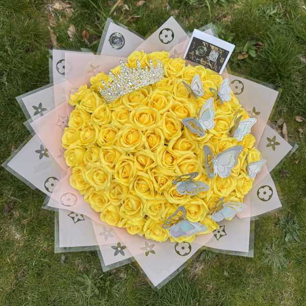 Round bouquet of yellow roses with a jeweled crown and butterfly decorations