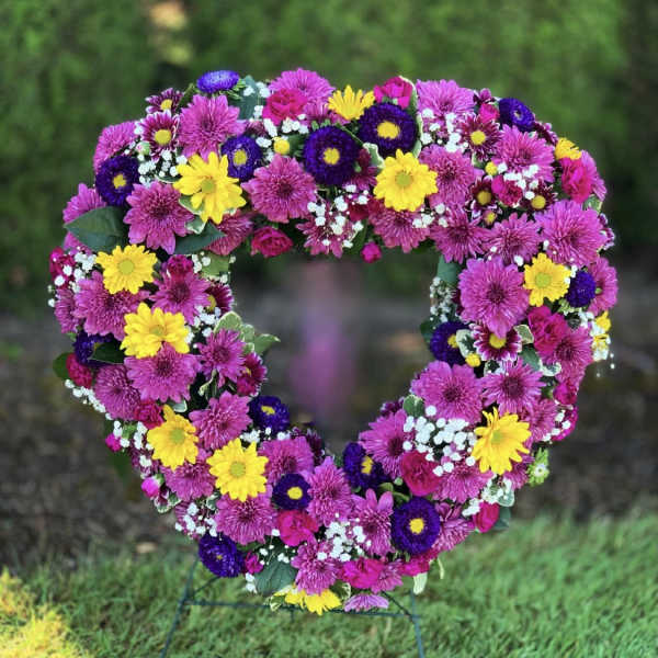 Heart-shaped floral wreath with pink, yellow, and purple flowers