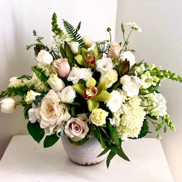Mixed white and blush floral arrangement in a gray vase
