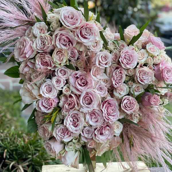 Large bouquet of pale pink roses with feathery pink accents