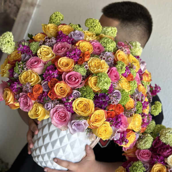 Large bouquet of multicolored roses in a white textured vase