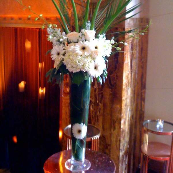 Tall white floral arrangement in a clear glass vase