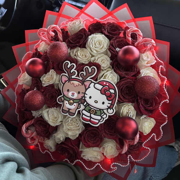 Bouquet of red and white roses with holiday ornaments and cartoon toppers
