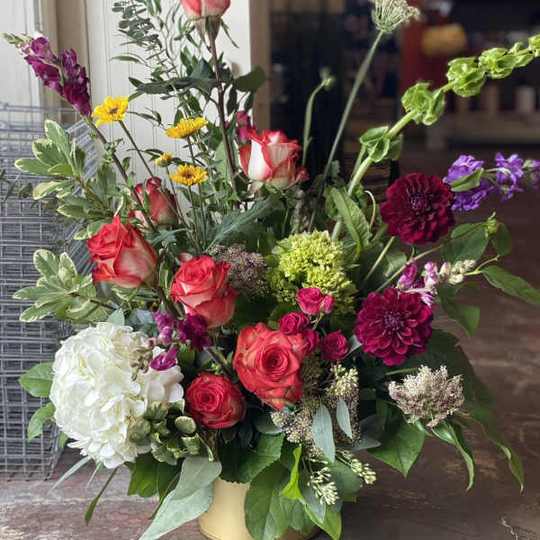 Mixed bouquet in a gold vase with roses, hydrangea, and dahlias