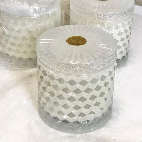 Three clear glass candle jars with geometric patterns and lids