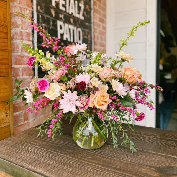 Mixed bouquet in a clear glass vase with pink and peach flowers