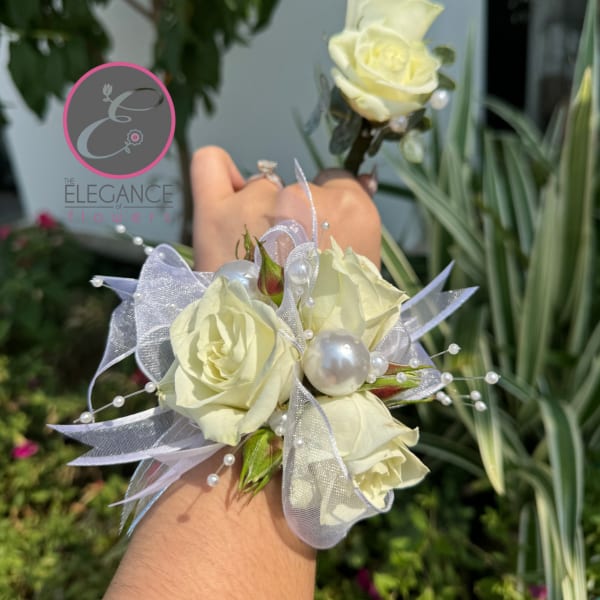 White rose corsage with pearl accents and sheer ribbon