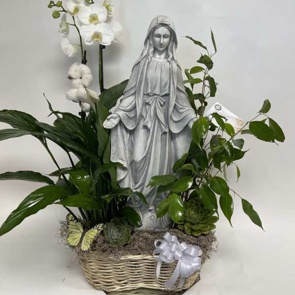White orchids and greenery arranged around a statue in a basket.