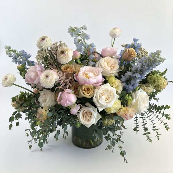 Large pastel bouquet in a dark glass vase