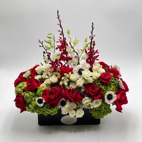 Red and white roses arranged in a black rectangular container