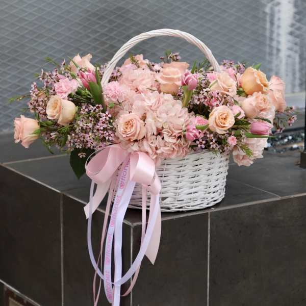 Pink and peach flower basket with a ribbon bow